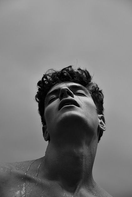 a man with no shirt on is looking up at the sky and has his eyes closed