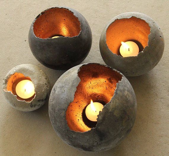 three cement bowls with candles in them on a table