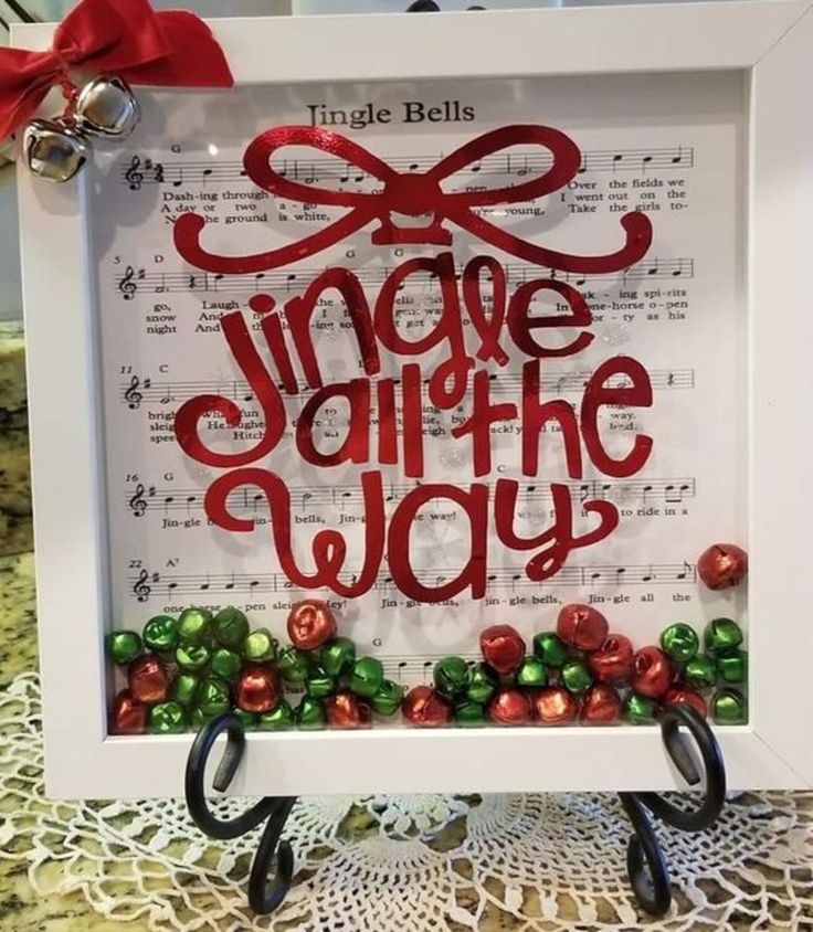 a white frame with red lettering and bells on it that says, imagine all the way