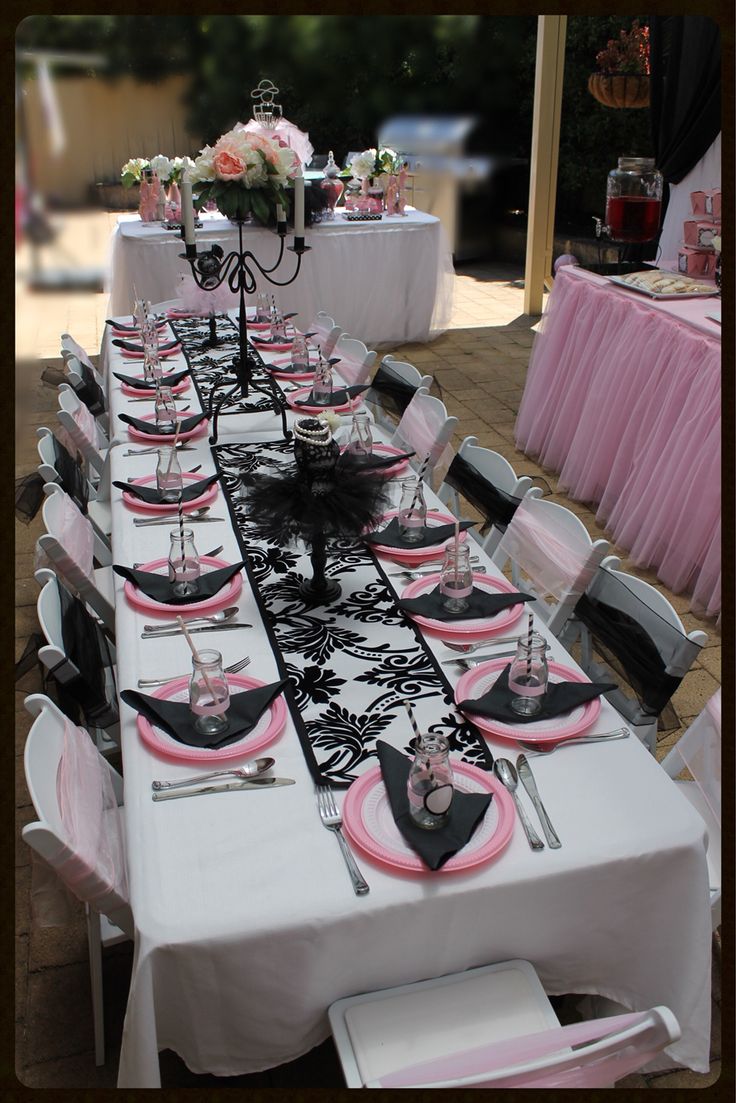 a table set up with pink and black place settings