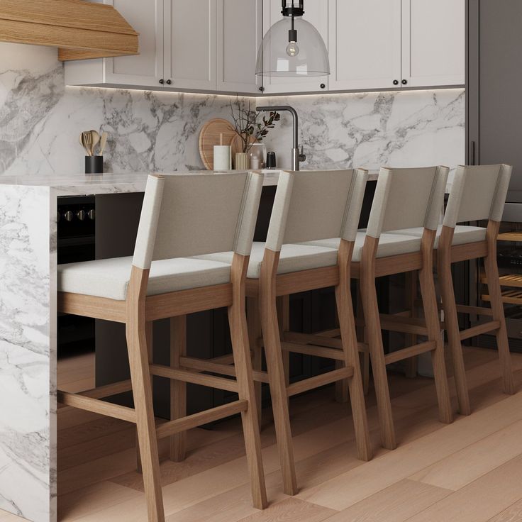 a kitchen with marble counter tops and wooden chairs in front of an island that's built into the wall