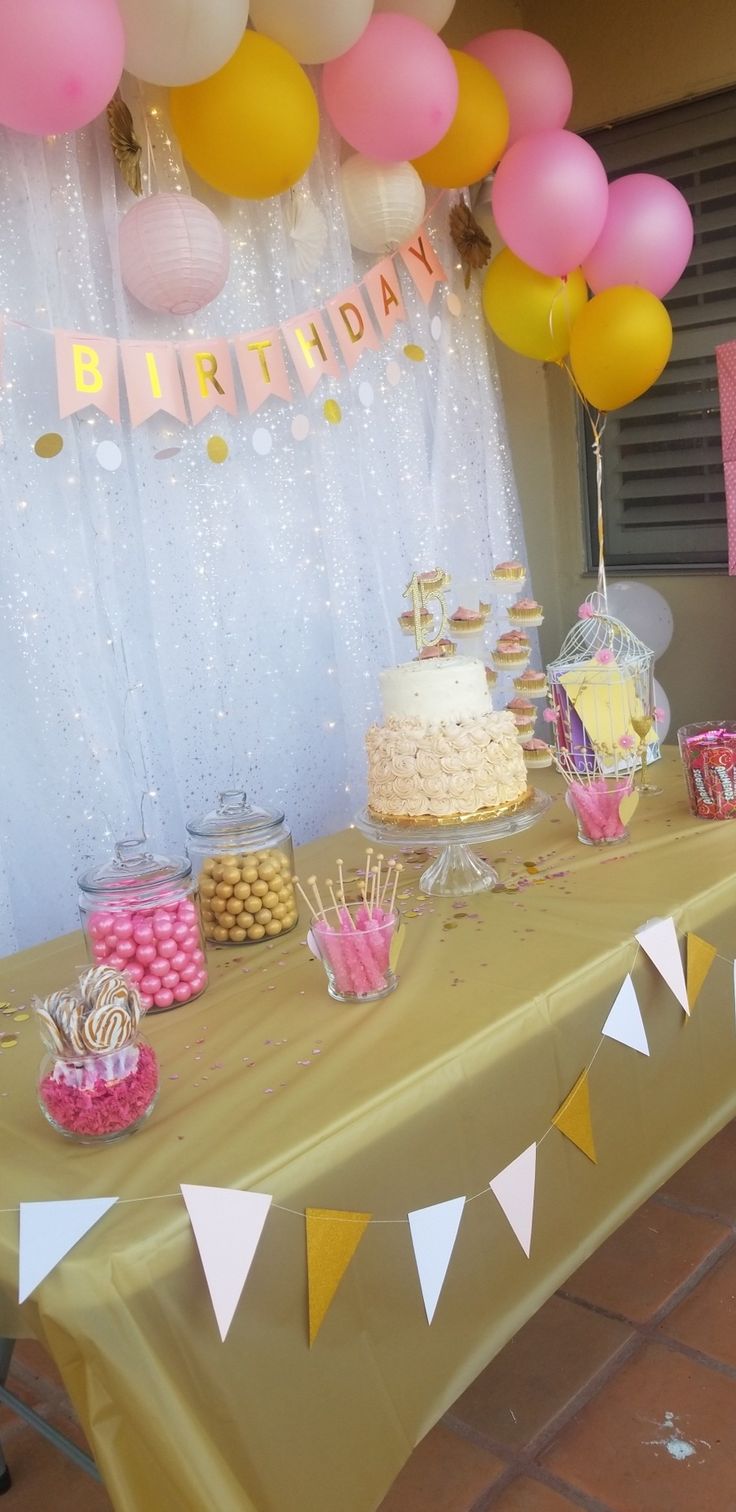 a table topped with lots of cake and balloons