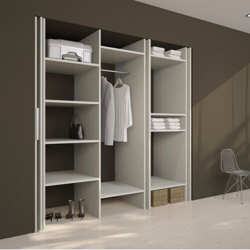 an open closet with clothes and shoes on shelves next to a chair in a room