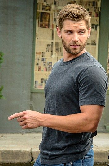 a man standing in front of a fire hydrant with his hand out to the side