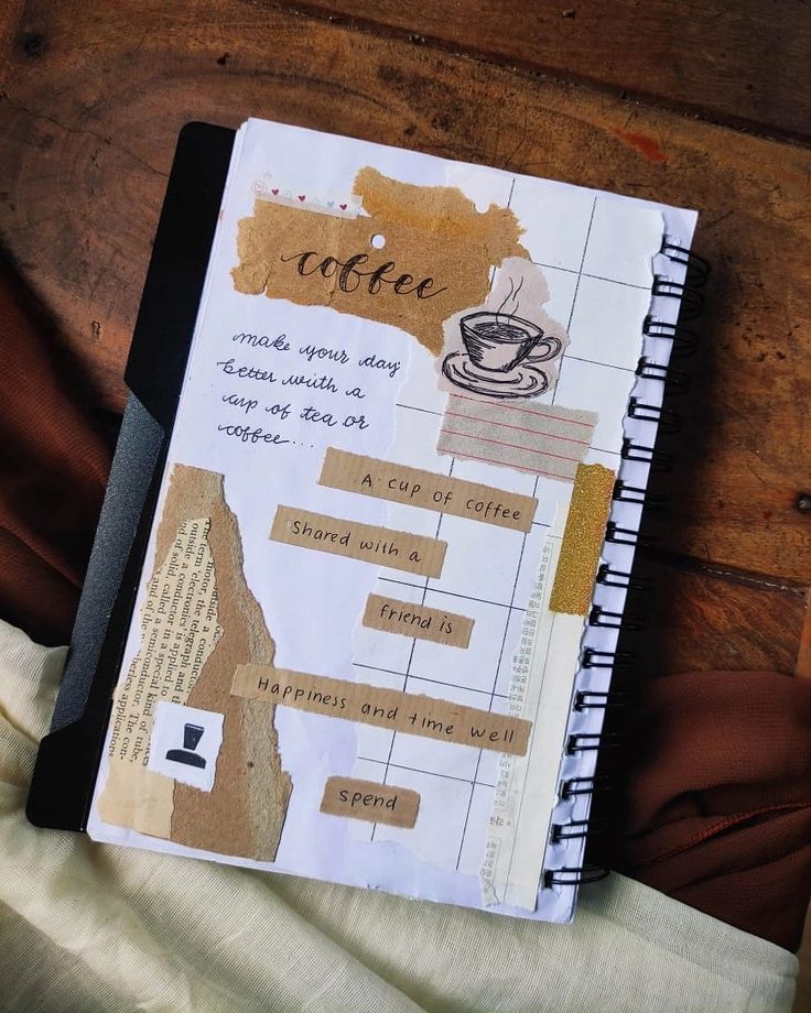 a notebook with coffee on it sitting on top of a wooden table