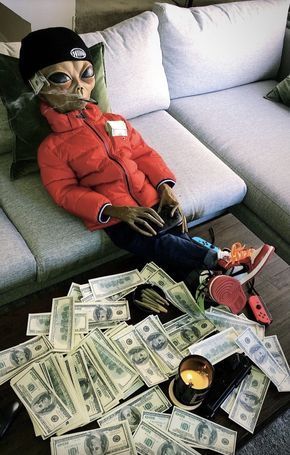 a doll sitting on top of a pile of money