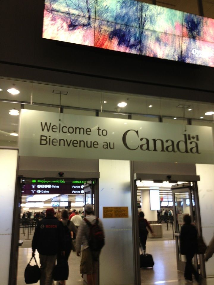 people are walking in and out of a building with the words welcome to canada on it