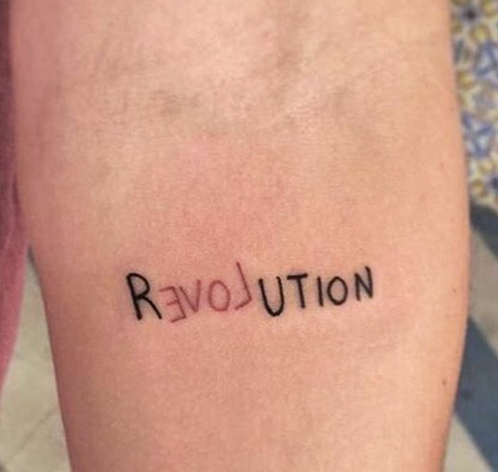 the word revolution written on someone's leg is shown in small black letters, which are