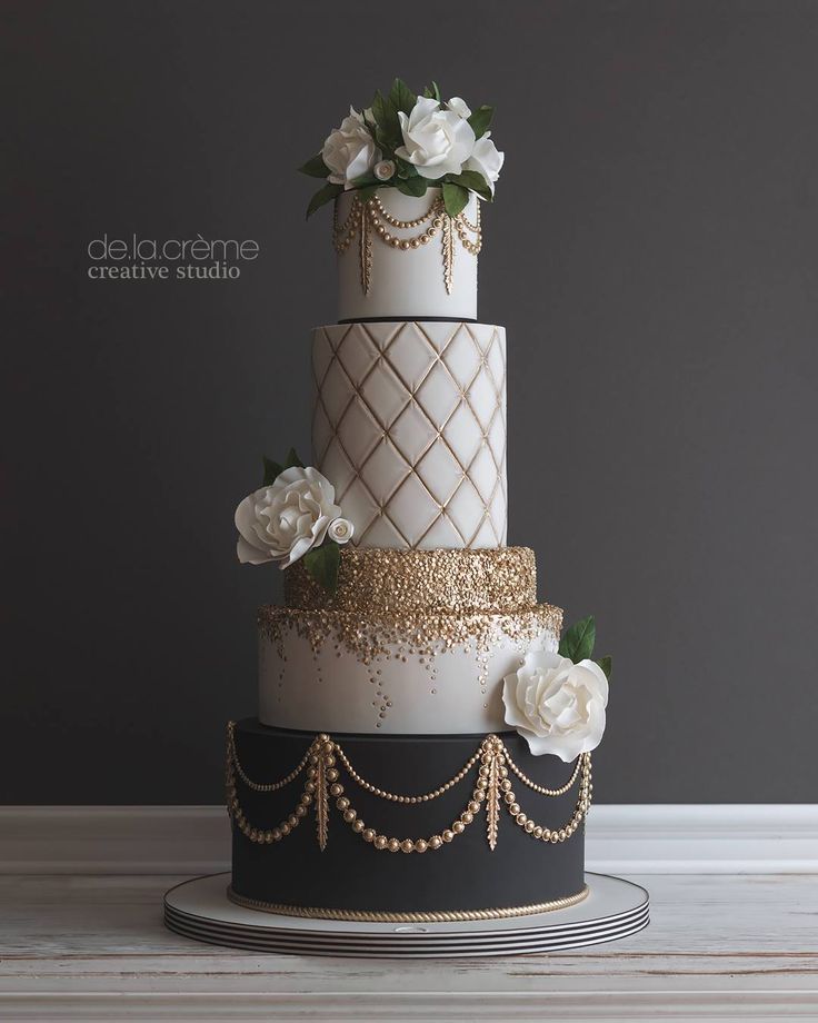 a white and black wedding cake with flowers on the top is featured in an instagram