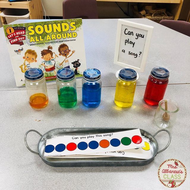 an assortment of different colored liquids on a table next to a sign that says sound's all around