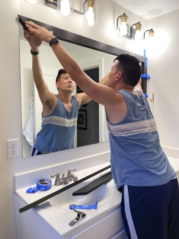 a man is doing something in front of the mirror