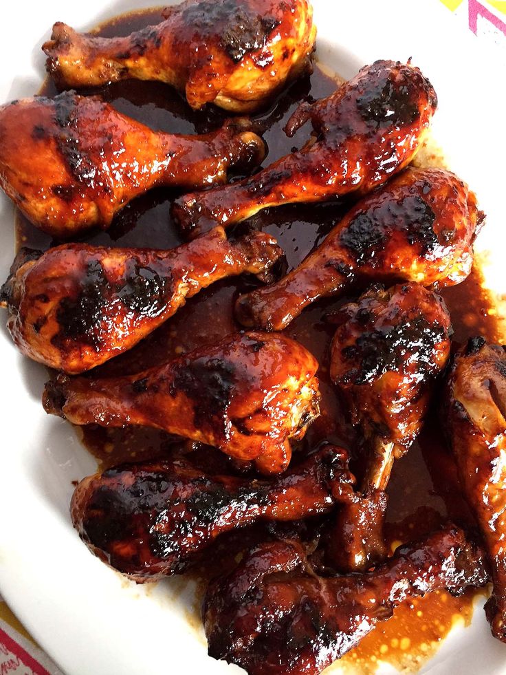 chicken wings covered in bbq sauce on a white plate