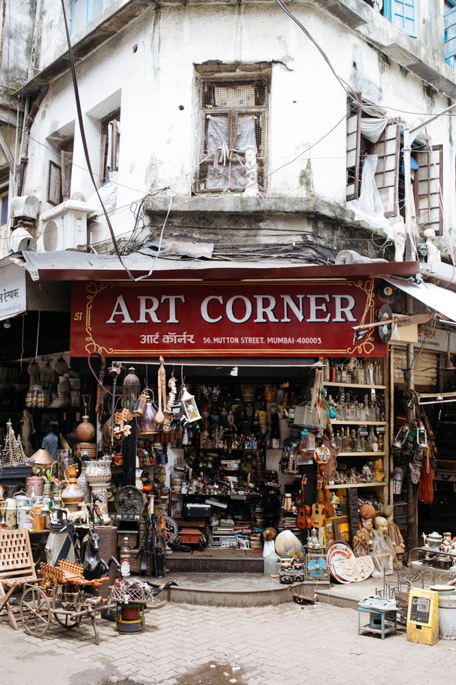 an art corner with lots of items on the ground and buildings in the background,