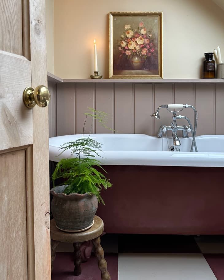 an old fashioned bathtub with a potted plant next to it