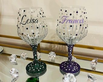 three wine glasses sitting next to each other on top of a table covered in diamonds