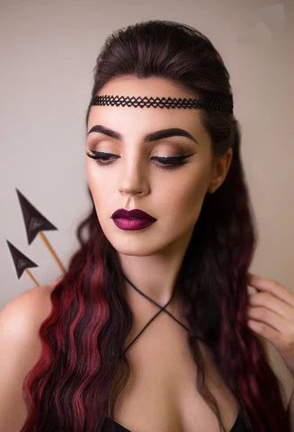 a woman with long hair wearing a black dress and red lipstick is posing for the camera