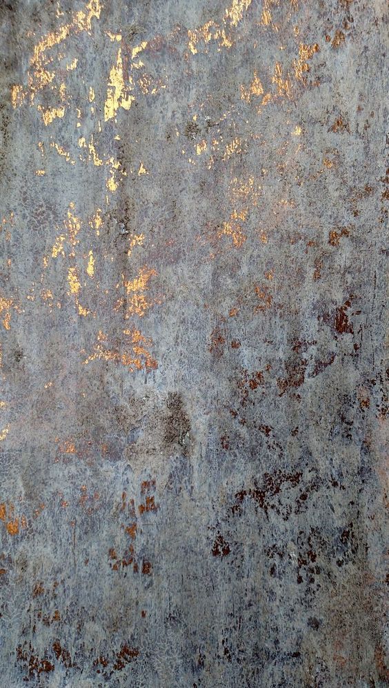 an old grungy surface with some yellow and brown paint on the top part of it