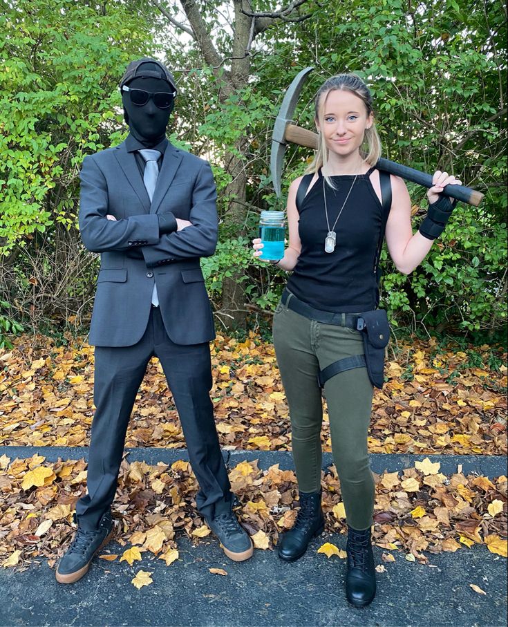 two people dressed up as ninjas standing next to each other in front of trees