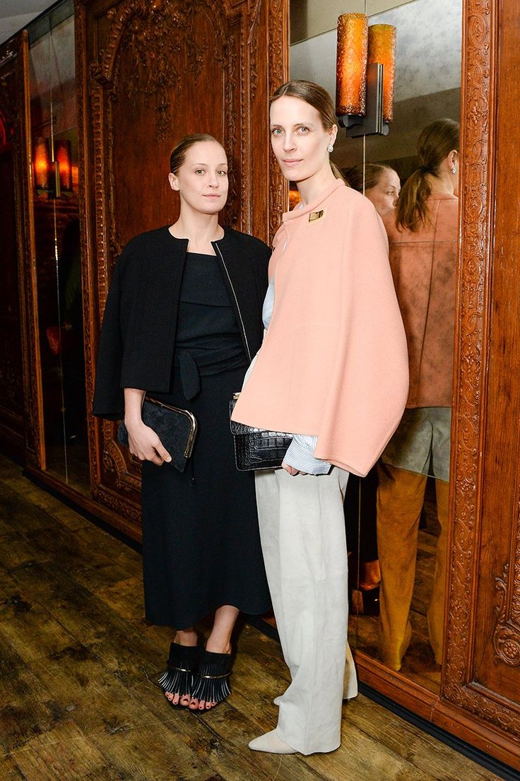 two women standing next to each other in front of a mirror