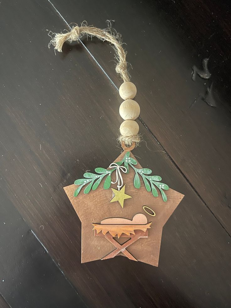 an ornament hanging from a string on top of a wooden table with beads