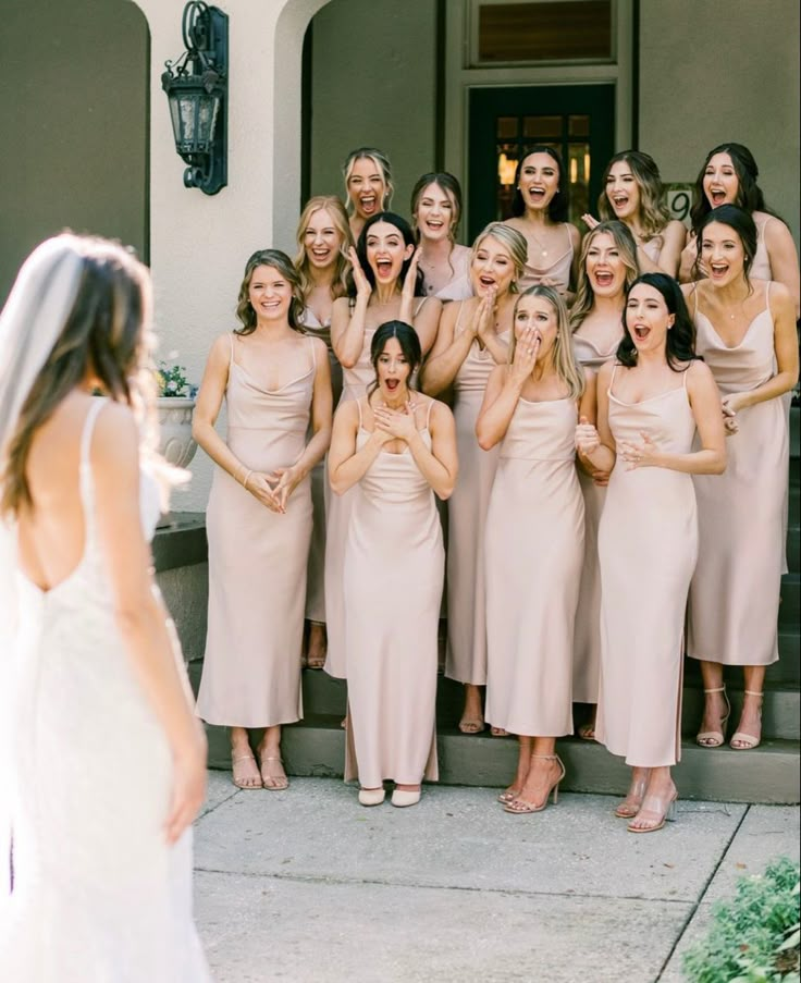 a group of women standing next to each other in front of a building with their mouths open