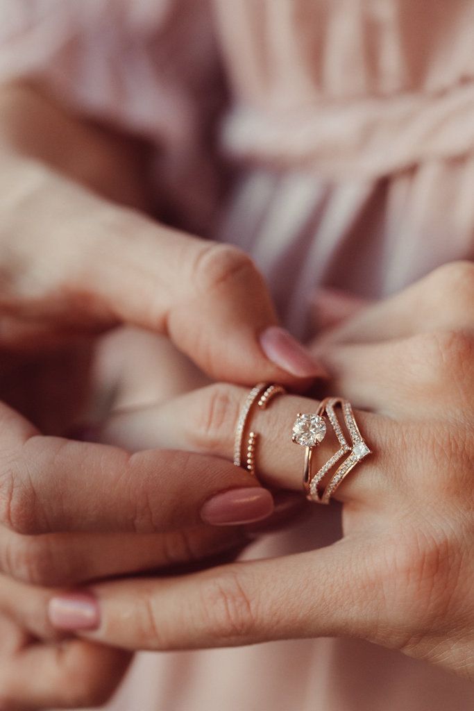 a woman is holding her wedding ring in her hands while she holds the other hand