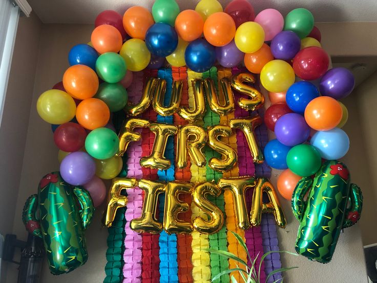 a bunch of balloons that say just first fiesta