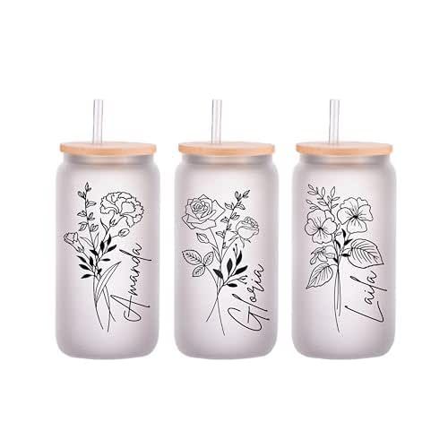 three glass bottles with floral designs on the lids and straws in each one, two are empty