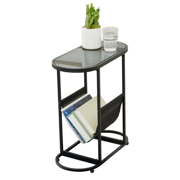 a small table with a magazine rack on it and a glass vase next to it