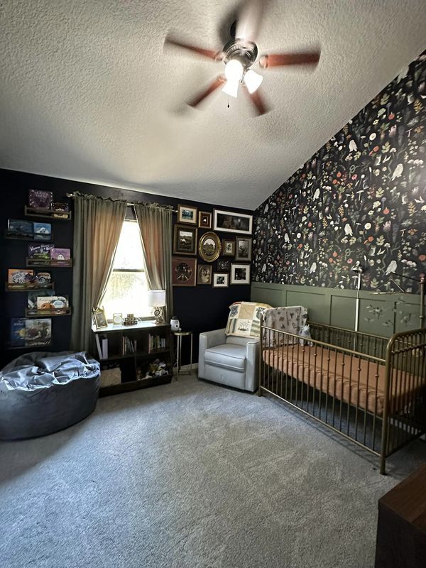 a baby's room with a crib, rocking chair and pictures on the wall