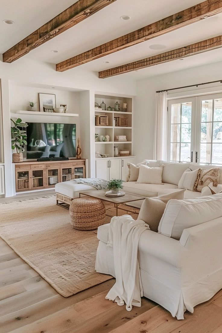 a living room filled with furniture and a flat screen tv on top of a wooden floor