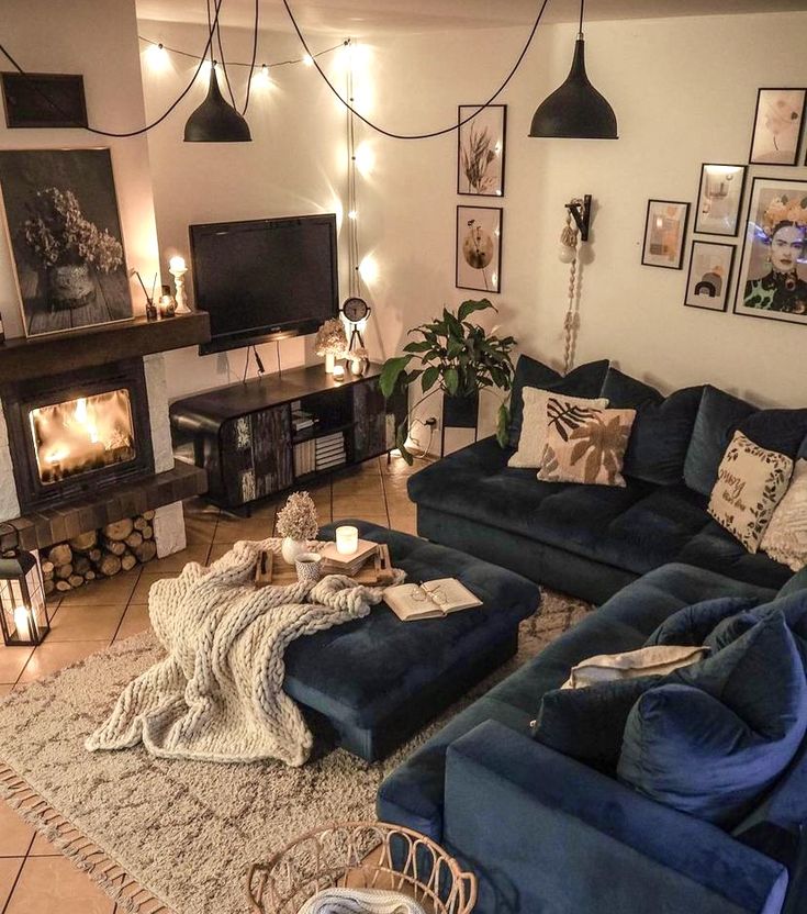 a living room with blue couches and pictures hanging on the wall above it's fireplace