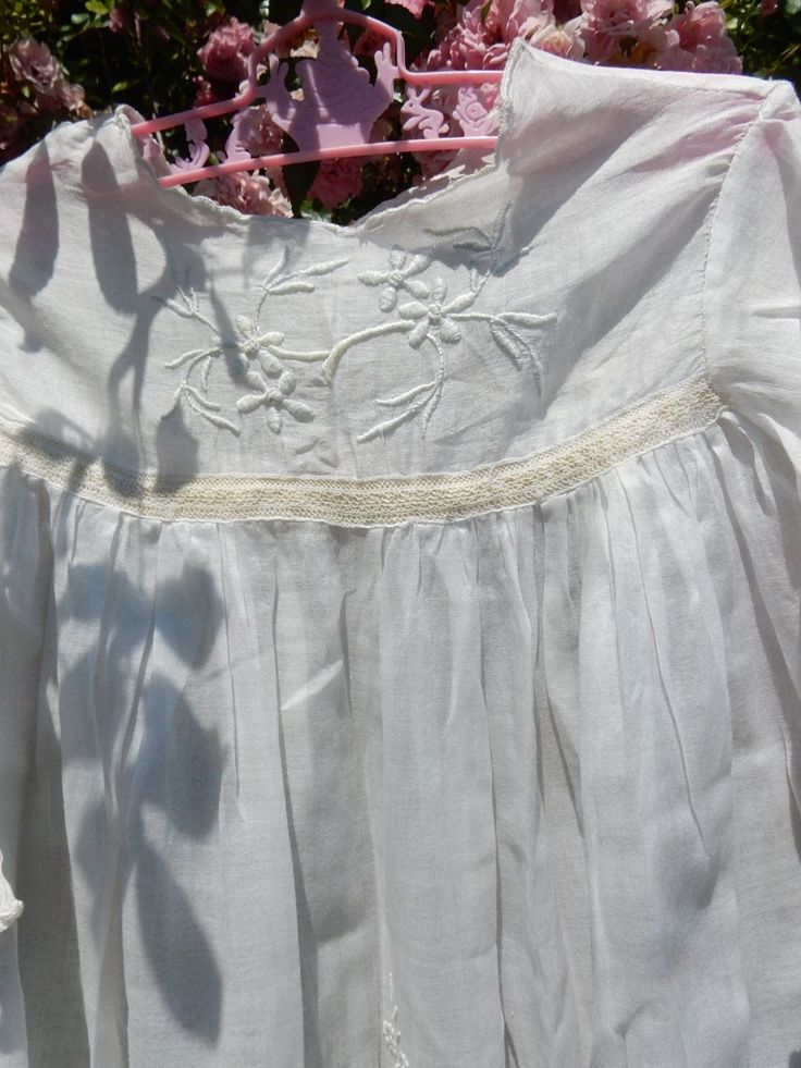 "This is an exquisite infant christening gown or dolls dress with whitework hand embroidery down the front and pintucks and insertion lace and lace ruffled hem. The yoke has a cream piece of insertion lace. It is made of very fine cotton voile batiste. The sleeves are long with lace insertion bands and the yoke has hand embroidery, and french seams throughout. There is a lot of hand-sewn french seams and 2 tiny buttons on the back for closure. Size is 27\" from underarm to underarm and 40\" from Insertion Lace, Lace Insertion, Lace Window, Dolls Dress, Christening Gown, Christening Gowns, French Seam, Gender Neutral Baby Clothes, Vintage Country