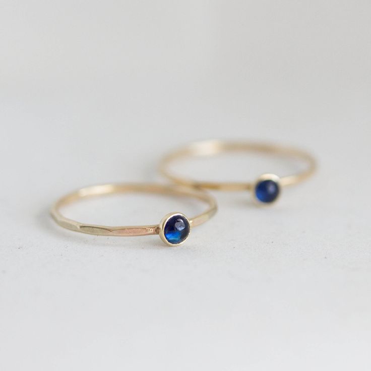 Tiny skinny stackable ring with beautiful deep blue Sapphire stone. It is made with a skinny but sturdy band, which allows you to create beautiful stacking sets! The ring is ideal for everyday wear and it will also look amazing with a festive dress. The ring is 0,8-0,9 mm thick and looks very dainty on the finger. Choose the finish of the stone (smooth cabochon or rose cut) and material for the ring (sterling silver or 9k gold). If you want to change the ring band design or get a custom ring or Tiny Sapphire Ring, Sapphire Stackable Birthstone Ring In 14k Gold, Minimalist Blue Stackable Rings In 14k Gold, Minimalist Blue 14k Gold Stackable Rings, Blue Stackable Midi Rings, Dainty Stackable Rings With Smooth Bezel, Stackable Promise Rings With Smooth Bezel, Everyday 14k Gold Moonstone Birthstone Ring, Adjustable Birthstone Midi Rings For Everyday Wear