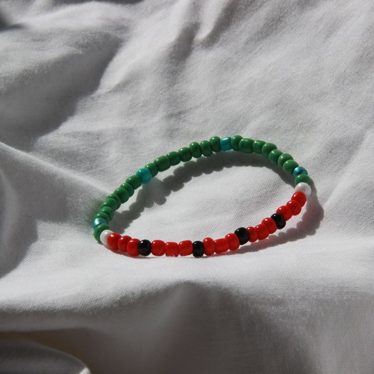 This Watermelon Bracelet is sure to bring a touch of summertime style to any outfit. Crafted from clay beads, it has a unique watermelon inspired design. Its small size makes it a great accessory for any occasion. Playful Handmade Green Stretch Bracelet, Playful Green Handmade Stretch Bracelet, Handmade Green Playful Friendship Bracelets, Colorful Beaded Bracelets For Everyday Summer Wear, Playful Handmade Green Friendship Bracelets, Green Tiny Beads Friendship Bracelets For Summer, Playful Green Adjustable Bracelets, Green Hand-strung Friendship Bracelets For Beach, Playful Green Friendship Bracelets With Colorful Beads