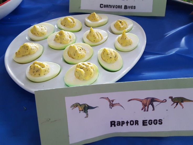 an egg tray filled with deviled eggs on top of a blue table