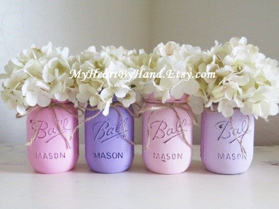 three mason jars with flowers in them are painted pink, purple and lilac colors