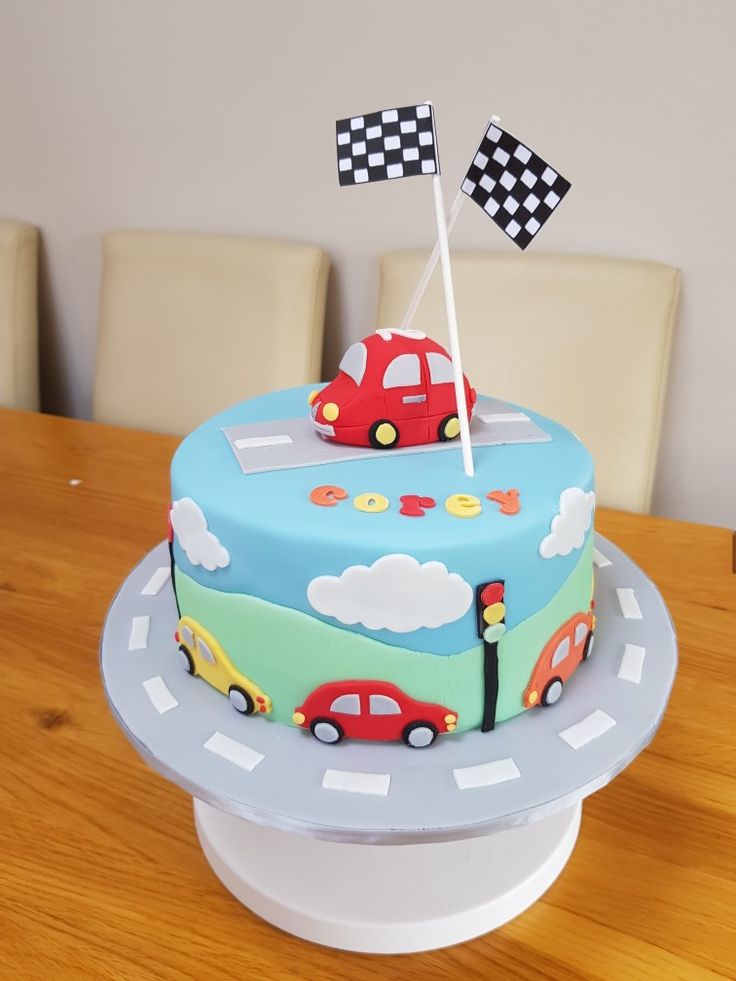 a birthday cake decorated with cars and checkered flags