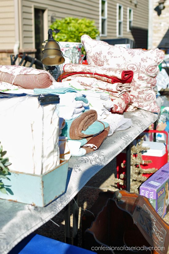 an outdoor table with clothes and other items on it