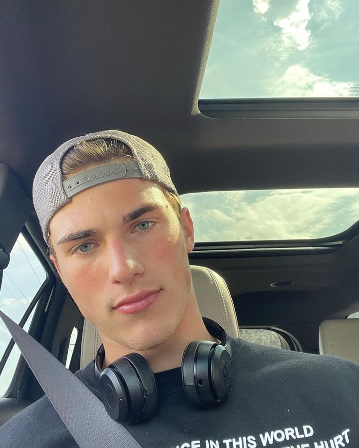 a man with headphones sitting in the back seat of a car