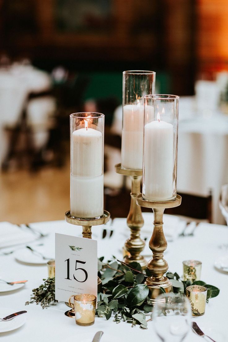 two candles sitting on top of a white table