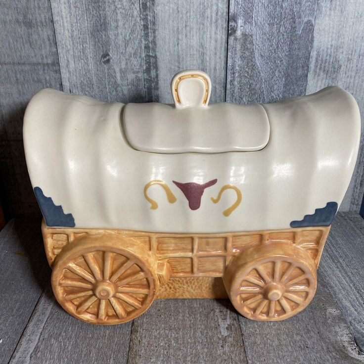 a ceramic toy horse drawn wagon with wheels