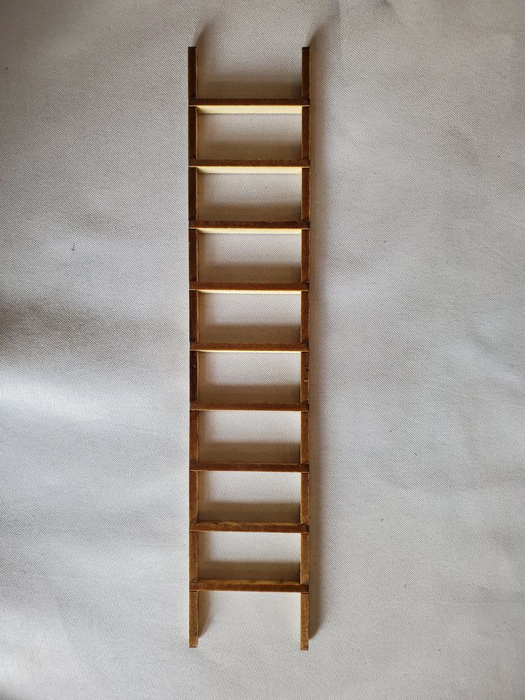 a wooden ladder leaning up against a white wall