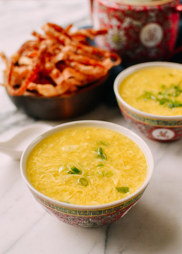 two bowls filled with soup next to some chips