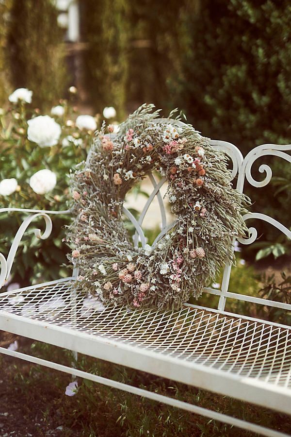 a white bench with a wreath on it