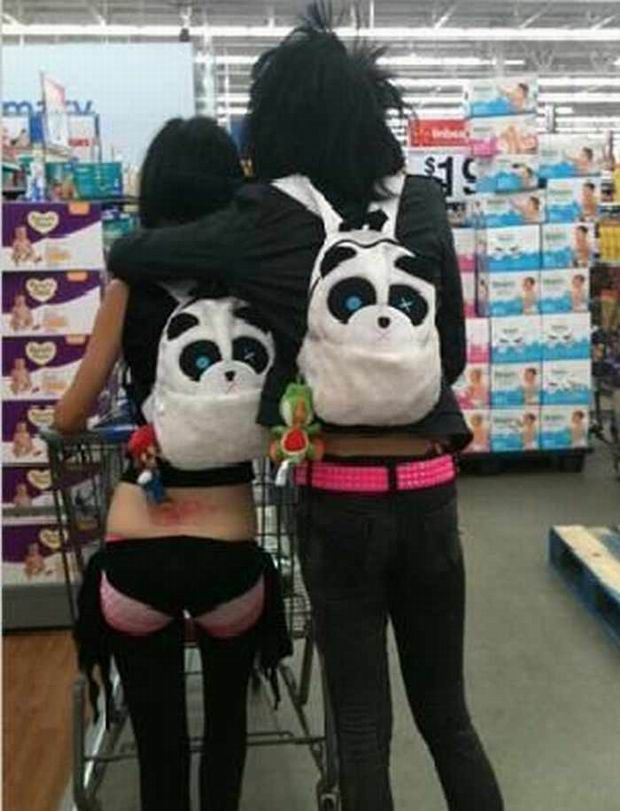 two women in panda costumes are pushing a shopping cart through a store with their back to the camera