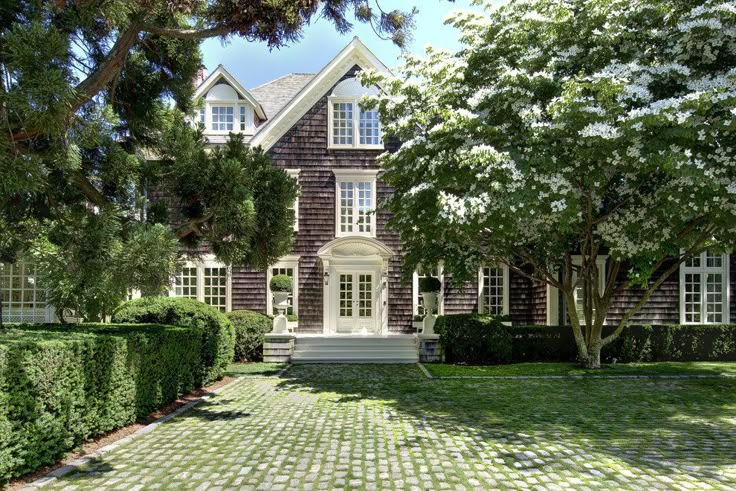 a large house surrounded by hedges and trees