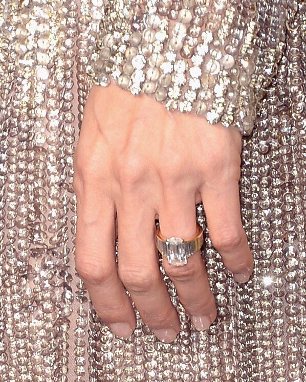 a close up of a person's hand with a ring on it