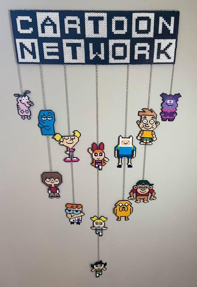 a cartoon network sign hanging from the side of a wall with various characters on it