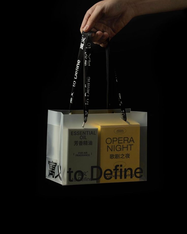 a person holding an open shopping bag with the words opera night written on it in chinese